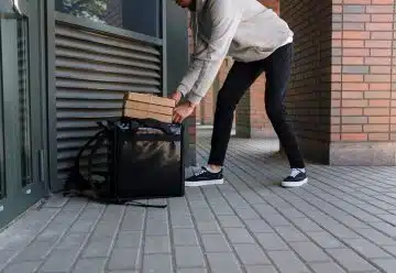 Man in White Dress Shirt and Blue Denim Jeans Holding Black Luggage Bag