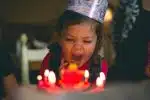 shallow focus photography of toddler blowing cake candles