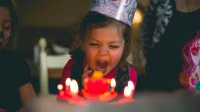 shallow focus photography of toddler blowing cake candles