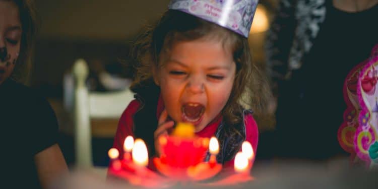 shallow focus photography of toddler blowing cake candles