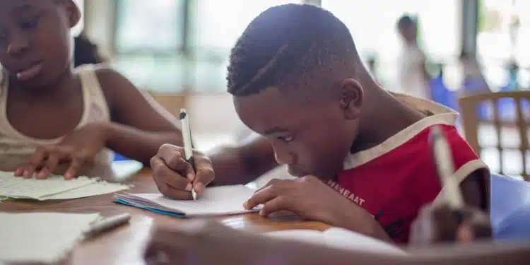 boy writing on printer paper near girl