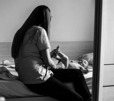 woman in white shirt and black pants sitting on bed